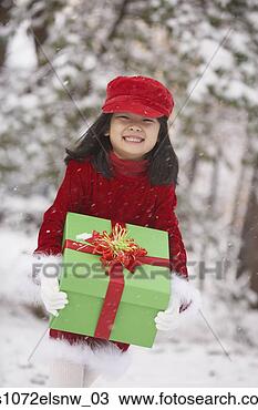Stock Photo - young asian girl 
holding gift in 
snow outdoors. 
fotosearch - search 
stock photos, 
pictures, images, 
and photo clipart