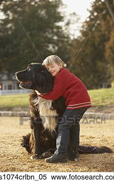 Stock Image - young boy hugging 
dog outdoors. 
fotosearch - search 
stock photos, 
pictures, images, 
and photo clipart