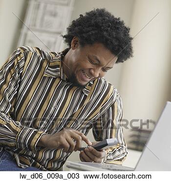 Stock Photo - african man using 
cell hone. fotosearch 
- search stock 
photos, pictures, 
images, and photo 
clipart