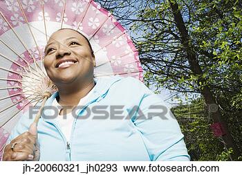 Stock Photo - african woman 
with parasol outdoors. 
fotosearch - search 
stock photos, 
pictures, images, 
and photo clipart