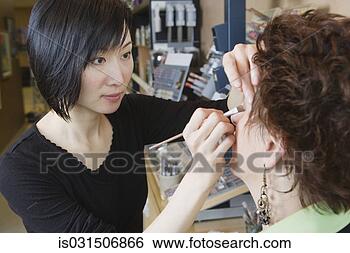 Stock Photo - asian female make 
up artist performing 
make over in salon. 
fotosearch - search 
stock photos, 
pictures, images, 
and photo clipart