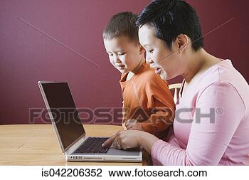 Stock Photo - asian mother and 
young son using 
laptop. fotosearch 
- search stock 
photos, pictures, 
images, and photo 
clipart
