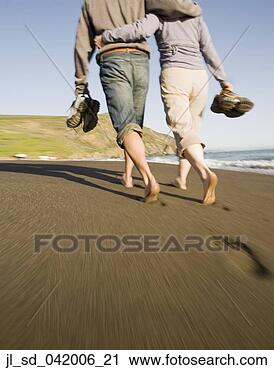 Stock Photography - couple walking 
barefoot on beach. 
fotosearch - search 
stock photos, 
pictures, images, 
and photo clipart