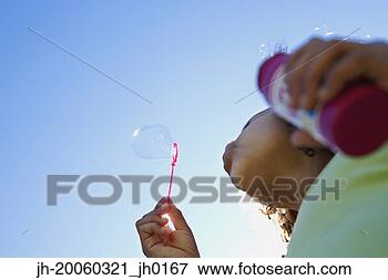 Picture - low angle view 
of girl blowing 
bubbles. fotosearch 
- search stock 
photos, pictures, 
images, and photo 
clipart