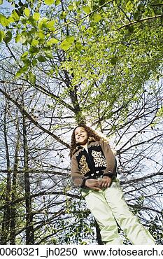 Stock Photography - low angle view 
of young girl 
under tree. fotosearch 
- search stock 
photos, pictures, 
images, and photo 
clipart