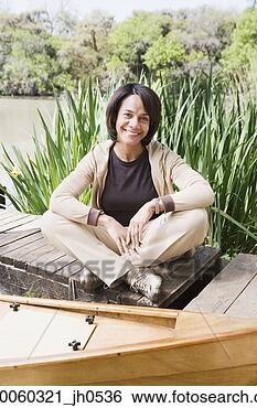 Stock Photo - middle-aged african 
woman sitting 
on dock smiling. 
fotosearch - search 
stock photos, 
pictures, images, 
and photo clipart