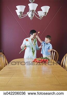 Stock Photo - mother and young 
son putting flowers 
in vase. fotosearch 
- search stock 
photos, pictures, 
images, and photo 
clipart
