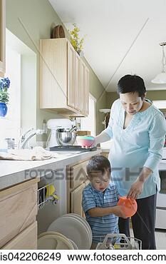 Stock Photograph - mother and young 
son putting dishes 
in dishwasher. 
fotosearch - search 
stock photos, 
pictures, images, 
and photo clipart