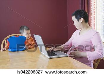 Picture - pregnant woman 
working at home 
with young son. 
fotosearch - search 
stock photos, 
pictures, images, 
and photo clipart