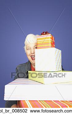 Stock Photo - studio shot of 
senior woman with 
stack of gifts. 
fotosearch - search 
stock photos, 
pictures, images, 
and photo clipart