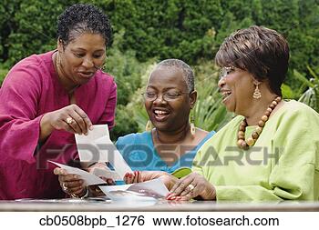 Stock Photo - three middle-aged 
african women 
looking at photographs. 
fotosearch - search 
stock photos, 
pictures, images, 
and photo clipart