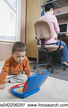 Picture - woman working 
at home with young 
son. fotosearch 
- search stock 
photos, pictures, 
images, and photo 
clipart