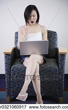 Picture - young asian woman 
using laptop in 
chair. fotosearch 
- search stock 
photos, pictures, 
images, and photo 
clipart