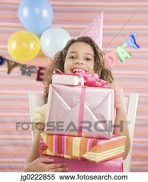 Stock Image - young girl holding 
stack of gifts 
at birthday party. 
fotosearch - search 
stock photos, 
pictures, images, 
and photo clipart