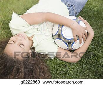 Stock Photograph - young girl laying 
on ground with 
soccer ball. fotosearch 
- search stock 
photos, pictures, 
images, and photo 
clipart