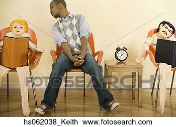 Stock Photo - african man sitting 
in waiting area 
next to blowup 
dolls. fotosearch 
- search stock 
photos, pictures, 
images, and photo 
clipart