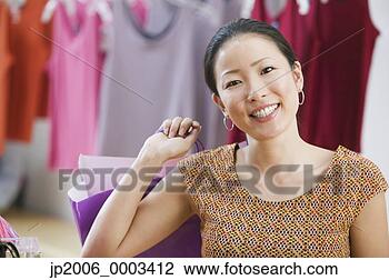 Stock Photo - asian woman smiling 
and holding shopping 
bag. fotosearch 
- search stock 
photos, pictures, 
images, and photo 
clipart