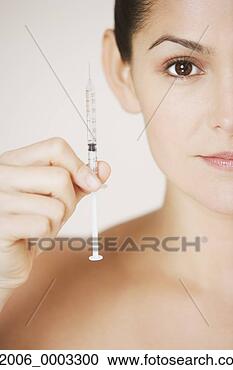 Stock Photography - close up studio 
shot of hispanic 
woman holding 
syringe. fotosearch 
- search stock 
photos, pictures, 
images, and photo 
clipart