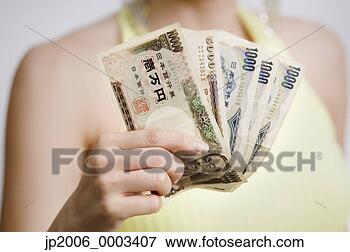 Picture - close up of woman 
holding fanned 
out money. fotosearch 
- search stock 
photos, pictures, 
images, and photo 
clipart