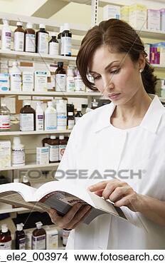 Stock Photo - female pharmacist 
looking at book 
in pharmacy. fotosearch 
- search stock 
photos, pictures, 
images, and photo 
clipart