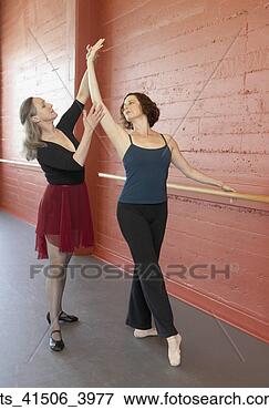 Picture - mature female 
ballet teacher 
helping adult 
female student. 
fotosearch - search 
stock photos, 
pictures, images, 
and photo clipart
