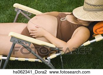 Stock Photo - pregnant woman 
laying in lawn 
chair wearing 
bathing suit. 
fotosearch - search 
stock photos, 
pictures, images, 
and photo clipart