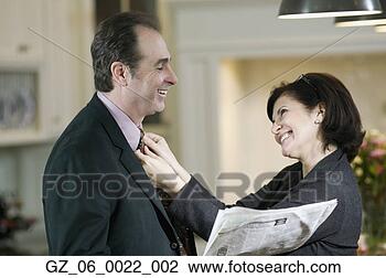 Stock Photo - woman adjusting 
man's tie and 
smiling. fotosearch 
- search stock 
photos, pictures, 
images, and photo 
clipart