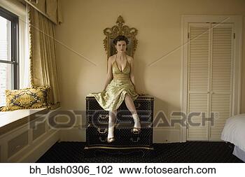 Stock Photo - woman in fancy 
dress sitting 
on dresser. fotosearch 
- search stock 
photos, pictures, 
images, and photo 
clipart