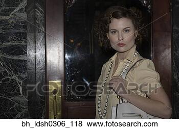Stock Photo - woman holding 
purse next to 
doorway. fotosearch 
- search stock 
photos, pictures, 
images, and photo 
clipart