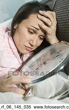 Stock Image - woman laying in 
bed with giant 
alarm clock. fotosearch 
- search stock 
photos, pictures, 
images, and photo 
clipart