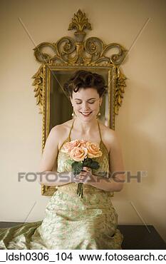 Stock Photo - woman wearing 
fancy dress and 
holding flowers. 
fotosearch - search 
stock photos, 
pictures, images, 
and photo clipart