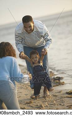Stock Photo - african father 
helping toddler 
walk to mother 
at beach. fotosearch 
- search stock 
photos, pictures, 
images, and photo 
clipart