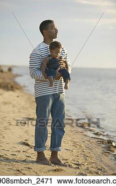 Stock Photography - african father 
holding baby at 
beach. fotosearch 
- search stock 
photos, pictures, 
images, and photo 
clipart