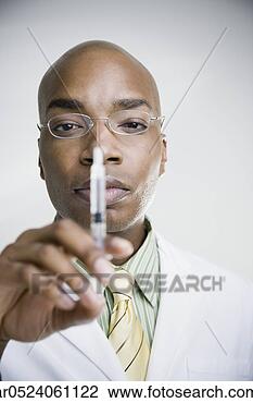Stock Photo - african male doctor 
holding syringe. 
fotosearch - search 
stock photos, 
pictures, images, 
and photo clipart