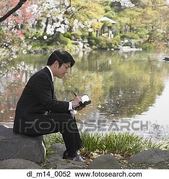 Stock Photo - asian businessman 
writing in day 
planner at park. 
fotosearch - search 
stock photos, 
pictures, images, 
and photo clipart