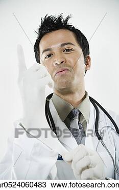 Stock Photo - asian male doctor 
putting on rubber 
glove. fotosearch 
- search stock 
photos, pictures, 
images, and photo 
clipart