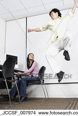 Stock Photo - asian man jumping 
next to asian 
female computer 
service technician. 
fotosearch - search 
stock photos, 
pictures, images, 
and photo clipart