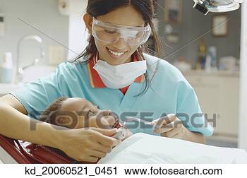 Stock Photography - indian female 
dental assistant 
working on african 
boy. fotosearch 
- search stock 
photos, pictures, 
images, and photo 
clipart