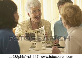 Picture - senior woman showing 
old photograph 
to friends. fotosearch 
- search stock 
photos, pictures, 
images, and photo 
clipart