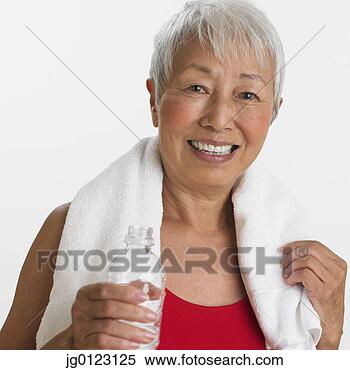 Stock Image - studio shot of 
senior asian woman 
with water and 
towel. fotosearch 
- search stock 
photos, pictures, 
images, and photo 
clipart