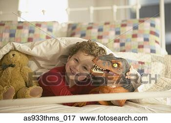 Picture - young boy smiling 
in bed with toy 
dinosaur. fotosearch 
- search stock 
photos, pictures, 
images, and photo 
clipart