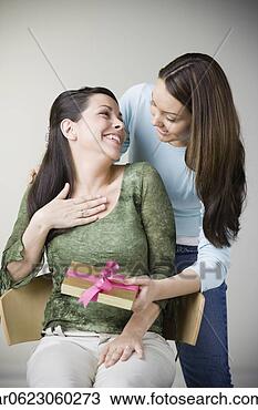 Stock Photo - hispanic girl 
giving gift to 
mother. fotosearch 
- search stock 
photos, pictures, 
images, and photo 
clipart