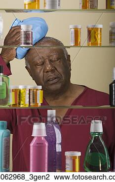 Stock Photo - sick senior african 
man in front of 
medicine cabinet. 
fotosearch - search 
stock photos, 
pictures, images, 
and photo clipart