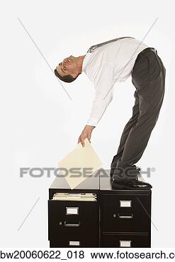 Stock Photo - studio shot of 
businessman bending 
over backwards 
on top of filing. 
fotosearch - search 
stock photos, 
pictures, images, 
and photo clipart