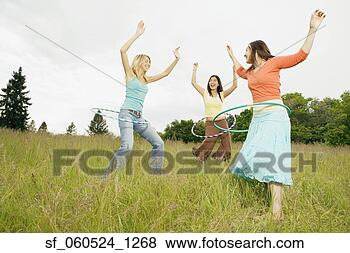 Stock Photo - three young women 
playing with hula 
hoops in meadow. 
fotosearch - search 
stock photos, 
pictures, images, 
and photo clipart