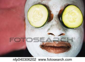 Stock Photo - african man with 
facial mask and 
cucumber slices 
on eyes. fotosearch 
- search stock 
photos, pictures, 
images, and photo 
clipart