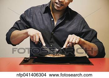 Stock Photo - asian man cutting 
meat on plate. 
fotosearch - search 
stock photos, 
pictures, images, 
and photo clipart