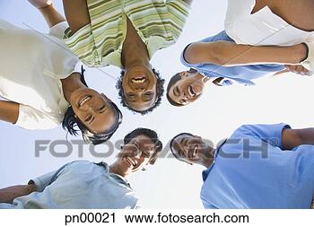 Stock Photography - low angle view 
of multi-ethnic 
friends in huddle. 
fotosearch - search 
stock photos, 
pictures, images, 
and photo clipart