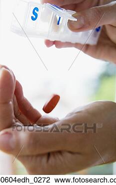 Stock Photo - man dropping pill 
out of pill organizer. 
fotosearch - search 
stock photos, 
pictures, images, 
and photo clipart