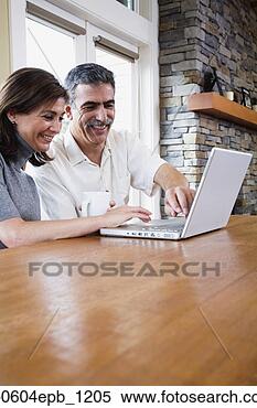 Stock Image - middle-aged couple 
typing on laptop. 
fotosearch - search 
stock photos, 
pictures, images, 
and photo clipart